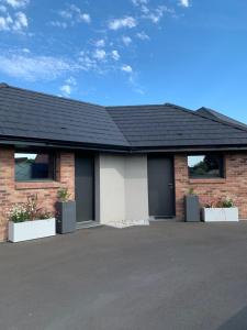 a brick house with a black roof at Les Chambres de Lily 1 in Lorgies