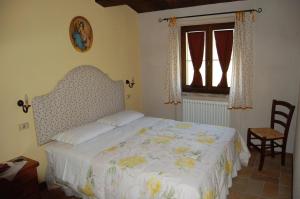 a bedroom with a bed and a chair and a window at Antica Dimora in Sarnano