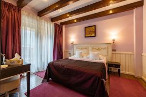 a hotel room with a bed and a desk at Casa Freya in Buşteni