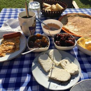una mesa con platos de comida en un paño de mesa azul en Guesthouse Mehmeti, en Valbonë