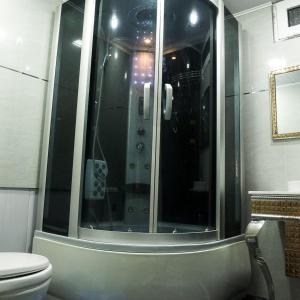 uma casa de banho com um WC e uma cabina de duche em vidro. em Bonuluxhome em Samarkand