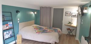 ein Schlafzimmer mit einem Bett und einer blauen Wand in der Unterkunft Le Chalet de Pyrène et Hercule in Arignac