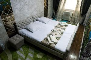 um quarto com uma cama num quarto com uma janela em Bonuluxhome em Samarkand