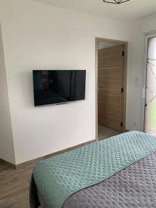 a bedroom with a bed and a flat screen tv on a wall at Les Chambres de Lily 2 in Lorgies