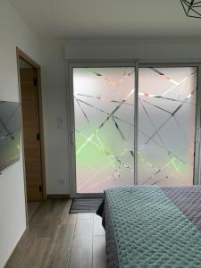a bedroom with a large glass window and a bed at Les Chambres de Lily 2 in Lorgies