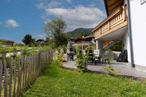 a backyard with a wooden fence and a patio at Haus am Bach in Kaprun