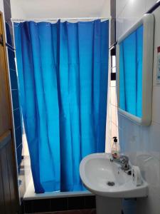a bathroom with a blue shower curtain and a sink at Di&Ana I - Alojamento Vila Viçosa in Vila Viçosa