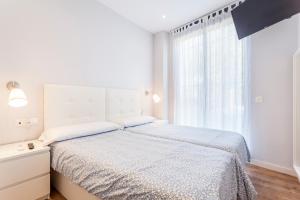バレンシアにあるConde de Melito Apartmentの白いベッドルーム(ベッド1台、窓付)