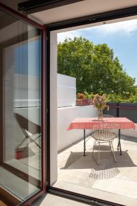 eine Glastür, die auf eine Terrasse mit einem Tisch führt in der Unterkunft Auberge hiribarren in Biriatou