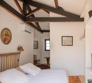 a bedroom with white walls and wooden beams at Auberge hiribarren in Biriatou