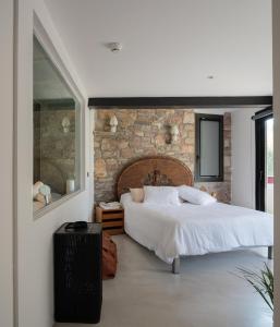 a bedroom with a bed and a stone wall at Auberge hiribarren in Biriatou