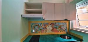 a kitchen with a sink and a painting on the wall at B&B Les Saisons de Jade in Nocera Superiore