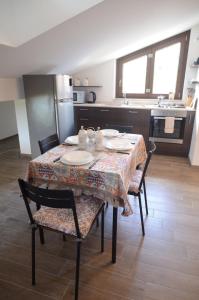 une cuisine avec une table et des chaises avec des assiettes. dans l'établissement FINALMENTE A CASA, à Capracotta