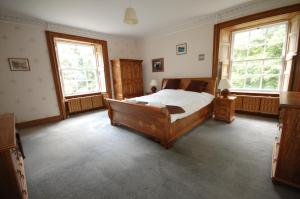 a bedroom with a bed and two windows at The Old Manse, Fochabers in Fochabers