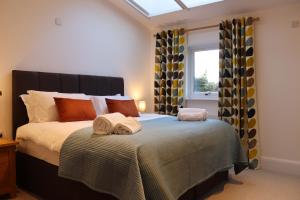 a bedroom with a bed with towels on it at The Anchorage Nables Farm in Chippenham