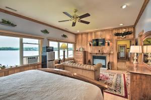 1 dormitorio con 1 cama grande y chimenea en Scenic Little Ossipee Lake Retreat with Grill! en North Waterboro