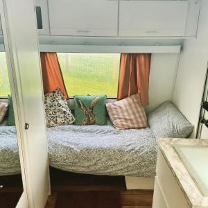 un lapin assis sur un lit dans une petite maison dans l'établissement Cosy Caravan at Carrigeen Glamping, à Kilkenny