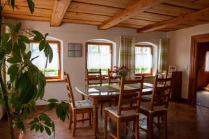 comedor con mesa, sillas y ventanas en Umgebindehaus an der Mandau, en Großschönau