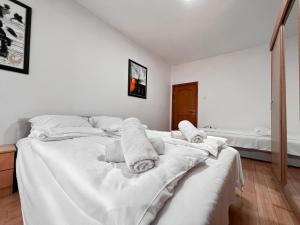 a bedroom with a white bed with towels on it at Stan na dan Sebastijan in Banja Luka