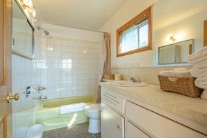 a bathroom with a sink and a tub and a toilet at Novastar Motel On The Lake in Yarmouth