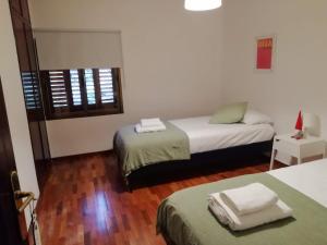 Pokój z 2 łóżkami, stołem i krzesłem w obiekcie Estupenda Villa con piscina a 5 minutos del centro de Granada w Grenadzie