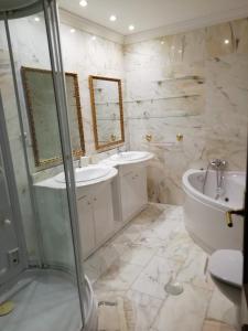 a bathroom with two sinks and a tub and a toilet at Estupenda Villa con piscina a 5 minutos del centro de Granada in Granada