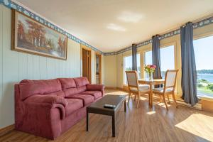 a living room with a red couch and a table at Novastar Motel On The Lake in Yarmouth
