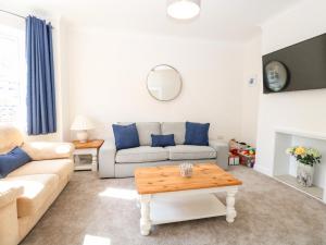 a living room with a couch and a table at The House in Gorleston in Great Yarmouth