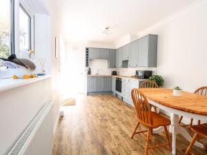 a kitchen and dining room with a wooden table and chairs at The House in Gorleston in Great Yarmouth