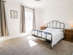 a white bedroom with a bed and a window at The House in Gorleston in Great Yarmouth