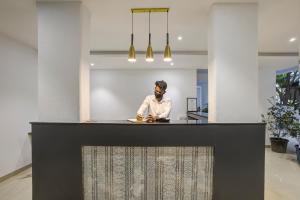 a man standing behind a counter in a room at StayBird - AERITH STUDIOS, Exclusive Residences, Kharadi in Pune