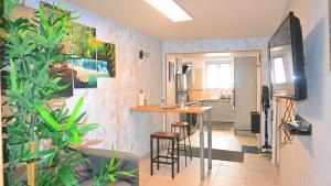 ヴィルヌーヴ・ス・ダマルタンにあるZEN Appartement 10mn CDG Airportのテーブルとキッチン付きの小さな部屋