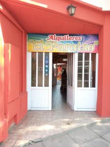 an entrance to a restaurant with a red building at El Paraiso in San Clemente del Tuyú