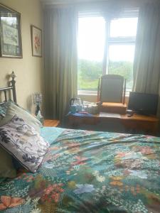 een slaapkamer met een bed met een kleurrijk dekbed en een raam bij Twenty in Lincolnshire
