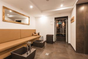 een wachtkamer met een bank en een spiegel bij Hotel Silvretta in Serfaus