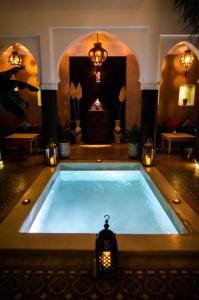 a large swimming pool in a room with lights at Riad Alnadine in Marrakesh