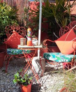 a patio with a table and chairs and plants at El Paraiso in San Clemente del Tuyú