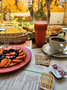 einen Tisch mit einem Teller Essen und einer Tasse Kaffee in der Unterkunft Eco Bunnu Inn in Cusco
