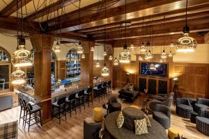 a lobby with a bar and some chairs and tables at ALPINE INN Davos in Davos