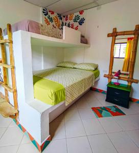 a bedroom with two bunk beds and a tiled floor at Divanga Hostel in Taganga