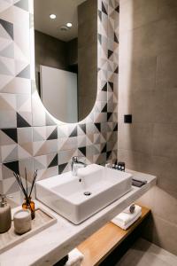 a bathroom with a sink and a mirror at Magico Suites City Heart Luxury Appartments in Alexandroupoli