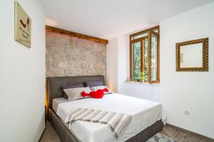 un dormitorio con una cama con un animal de peluche rojo en Stone oasis Vito en Dubrovnik