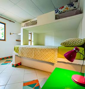 a room with a bed, a chair, and a window at Divanga Hostel in Taganga