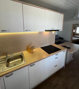 una cocina con armarios blancos y fregadero en ZEN MURTER Mobil home en Betina