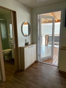 a bathroom with a toilet and a mirror and a door at ZEN MURTER Mobil home in Betina