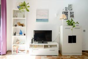 a living room with a television on a white cabinet at Apartamento Playa Maria con parking in Fuengirola