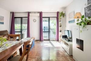 a living room with purple curtains and a dining table at Apartamento Playa Maria con parking in Fuengirola