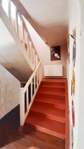 a staircase in a house with red wooden floors at Guest House Tall Rooms in Zugdidi