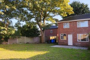 una casa in mattoni con un albero nel cortile di Bee Stays - Byron House a Manchester