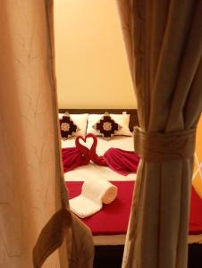 蒂魯吉拉帕利的住宿－Arangan Kudil，卧室配有红色和白色的床和窗帘